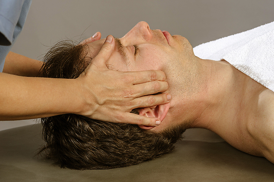 Händer som masserar käkar. Käkledsbehandling Luthagens Massage i Uppsala